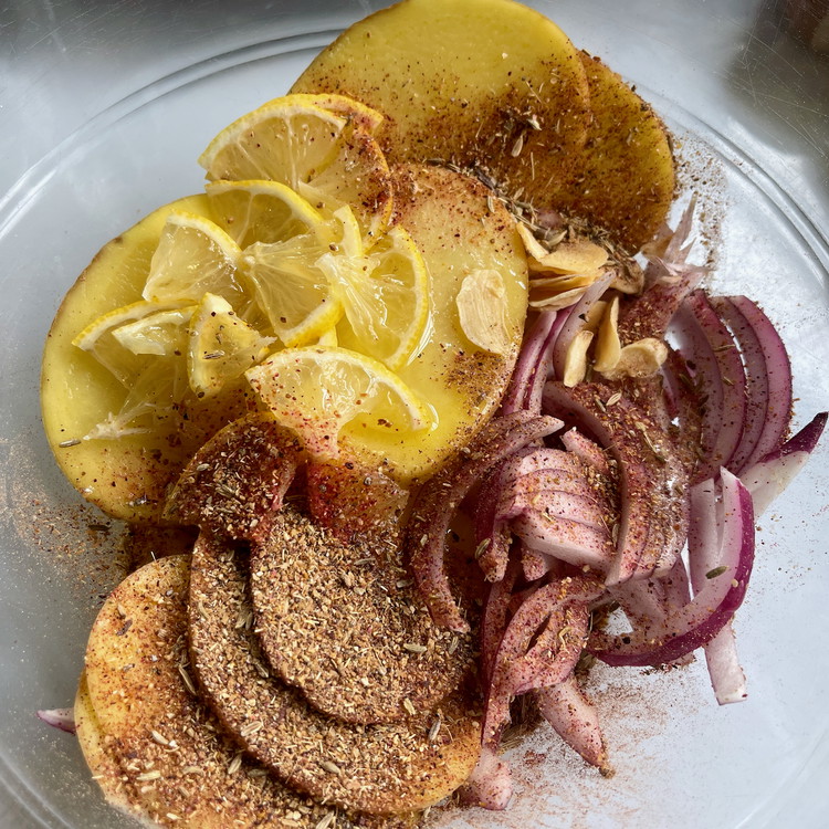 Image of In a large bowl, mix the potato slices, onion slices, dried garlic, Breeze, olive oil, salt, and lemon ¼’s to combine well.